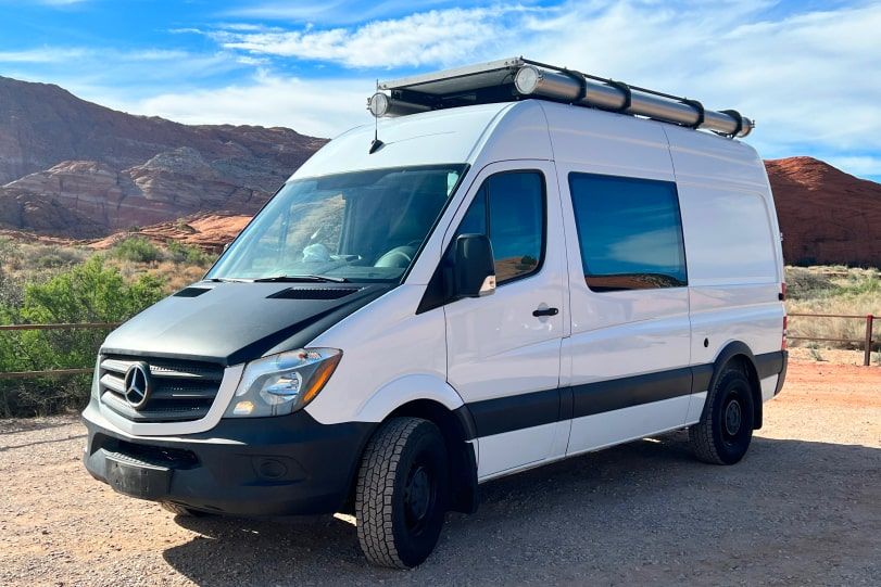 White Class B van with lifted tires